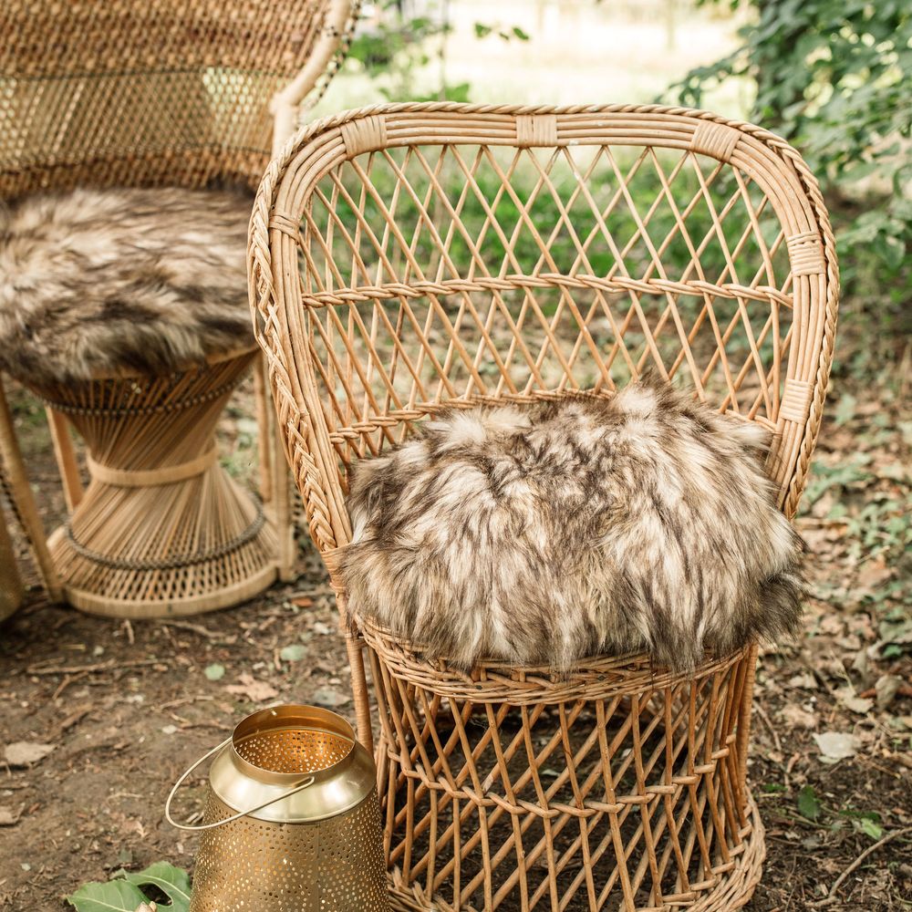 Wicker chair with fur pillow in grey and black