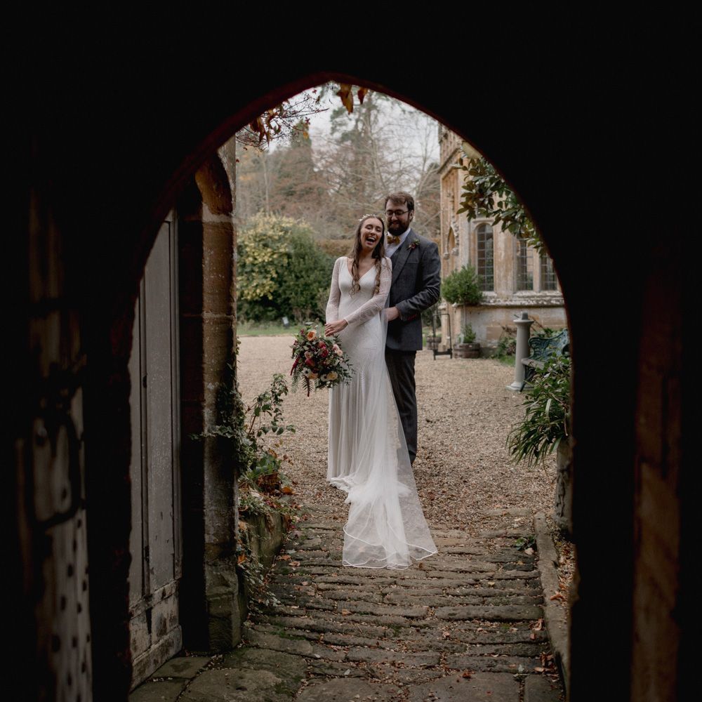 Bride and groom stood in archway on their wedding day