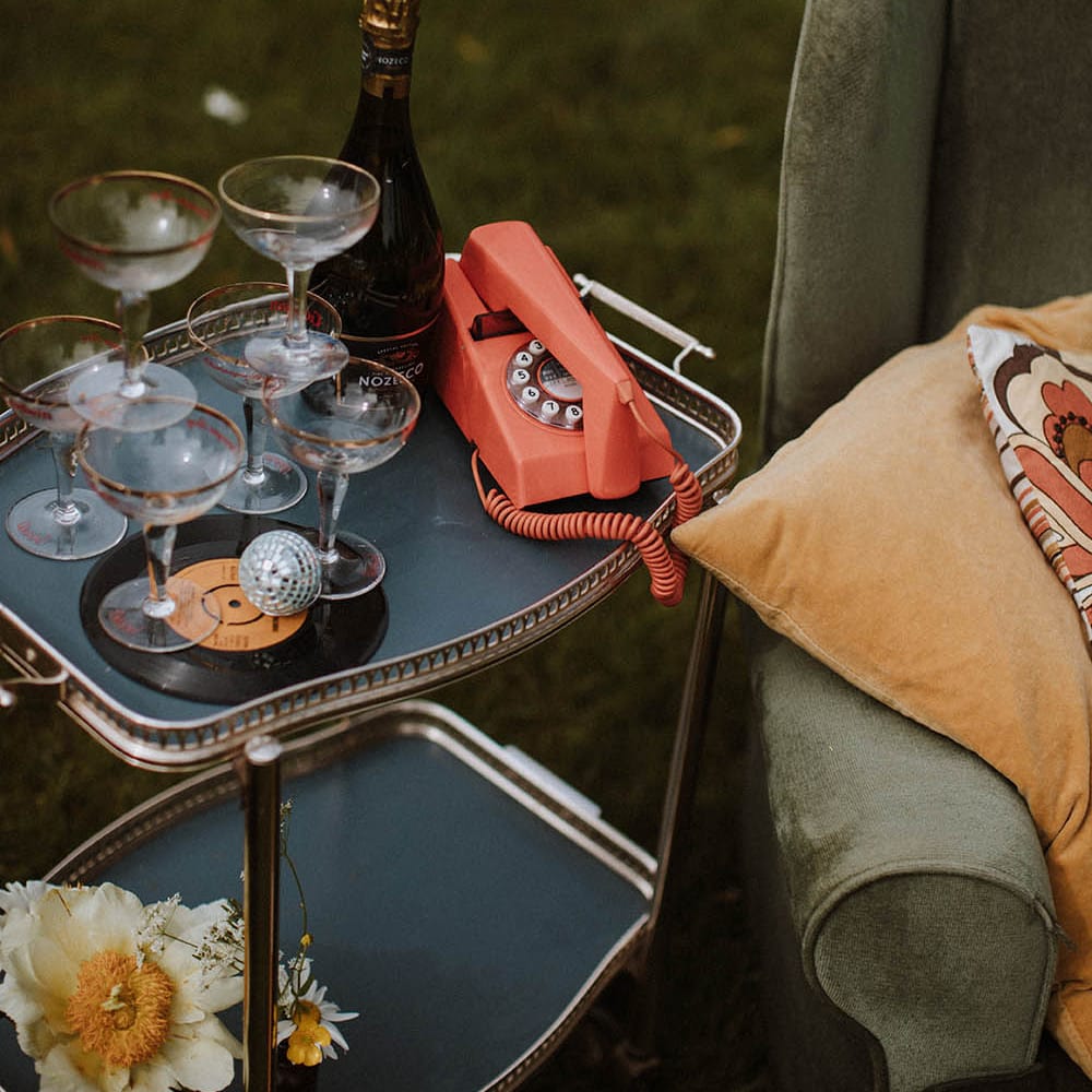 Drinks trolly with coupe champagne glasses and retro telephone