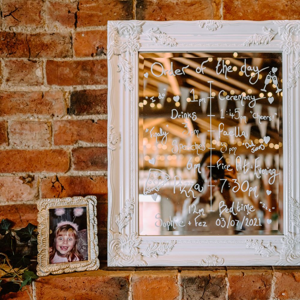 Order Of The Day written on mirror with pictures of brides as children next to it