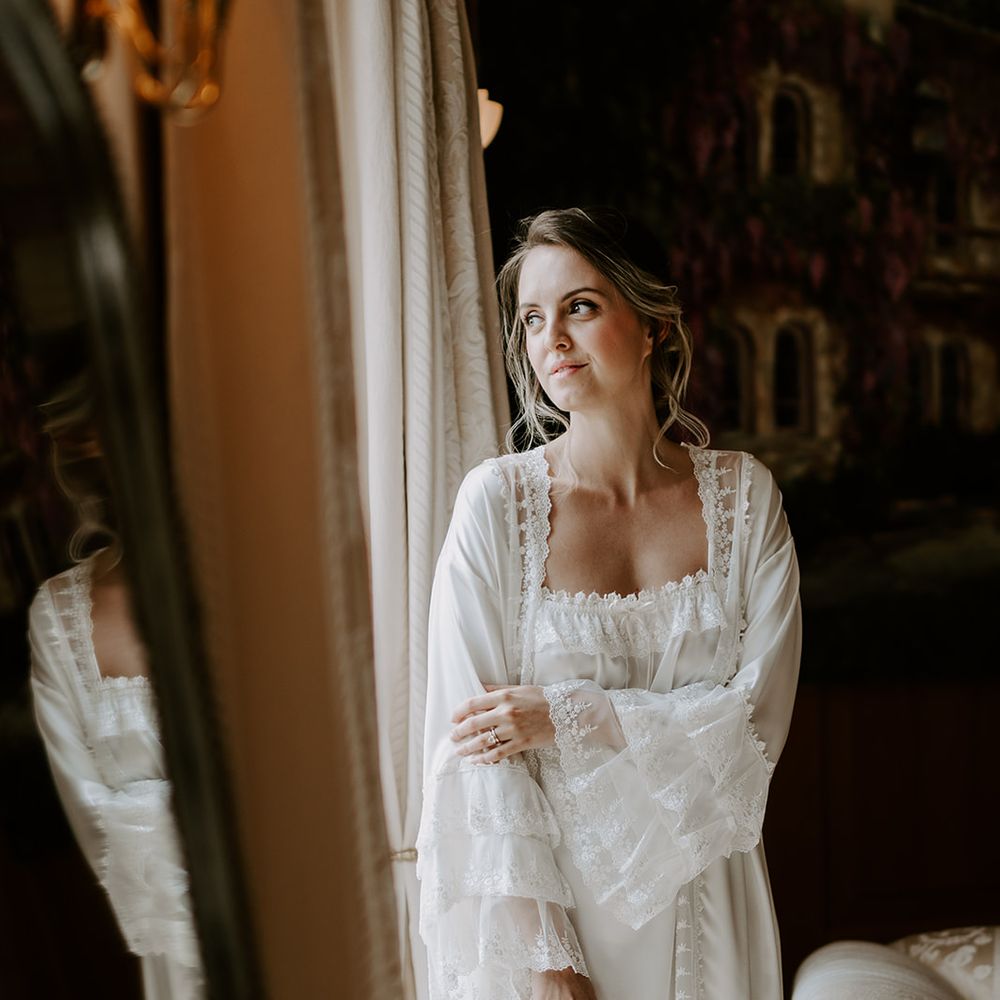 Bride in a delicate white getting ready robe with lace detail by Silk Garter