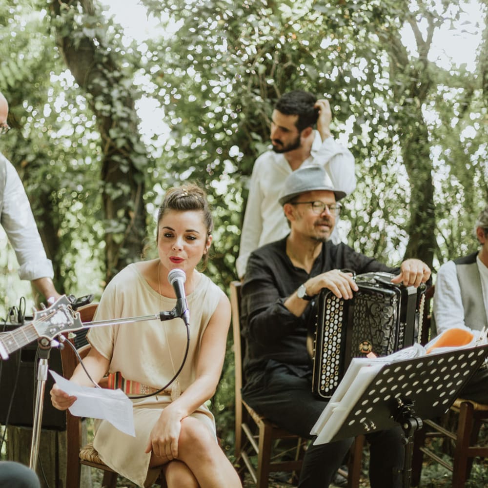 Wedding band performing during woodland wedding ceremony at destination wedding