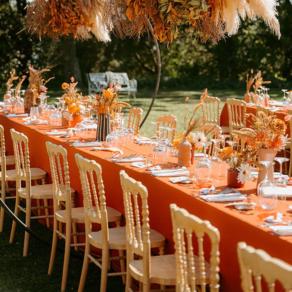Orange-themed table decor with dramatic overhanging flowers by Federica Mazzieri Photography