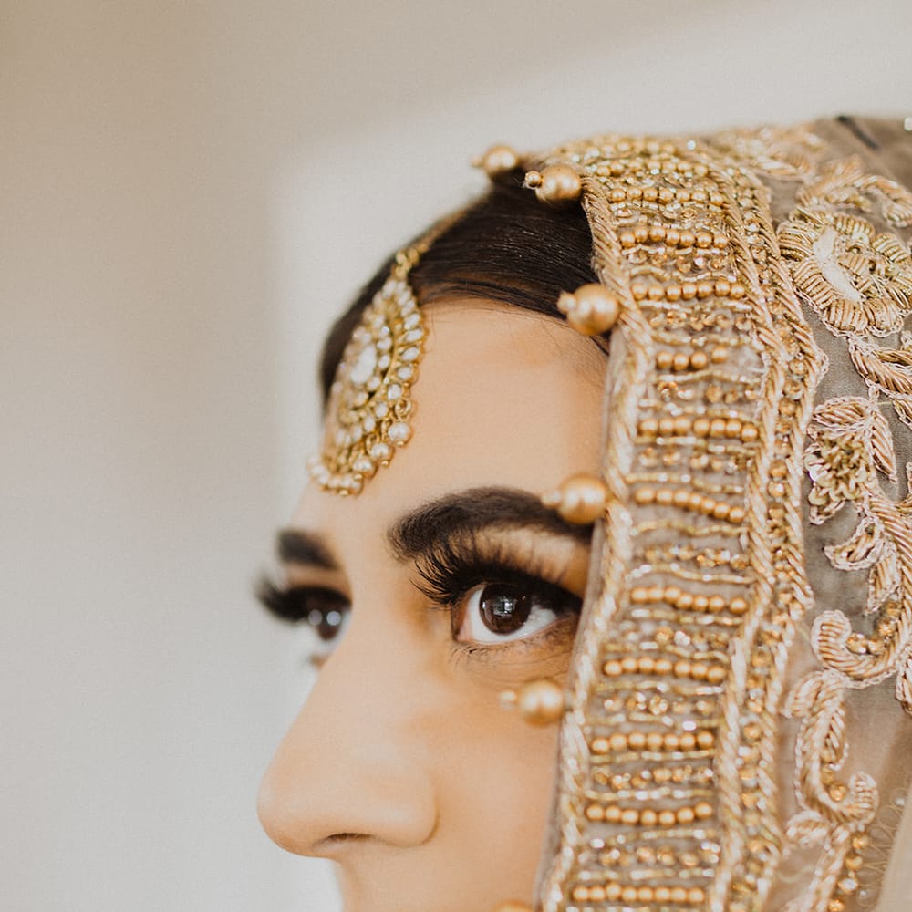 Muslim bride with red lipstick and gold wedding veil 