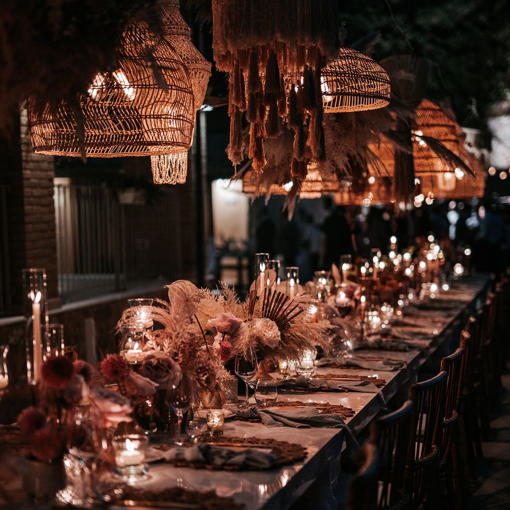 Outdoor wedding reception with shell and macrame hanging installation, candlelight and dried flower centrepieces 
