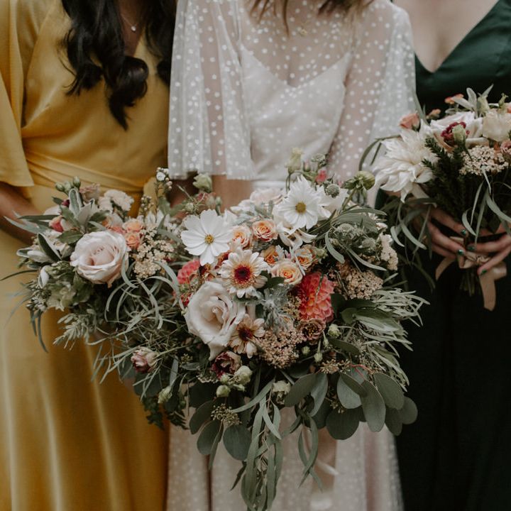 Bride & friends hold floral bouquets complete with neutral tones and sage green accent colour