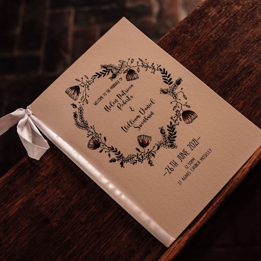 Wedding order of service on textured paper with white ribbon and ink flower illustrations for church ceremony