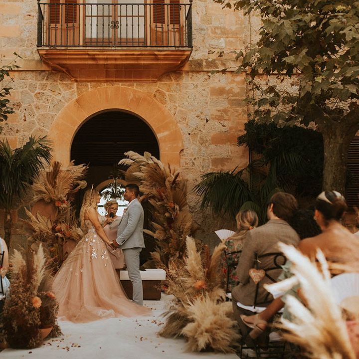 Bride & groom stand holding hands for outdoor ceremony 