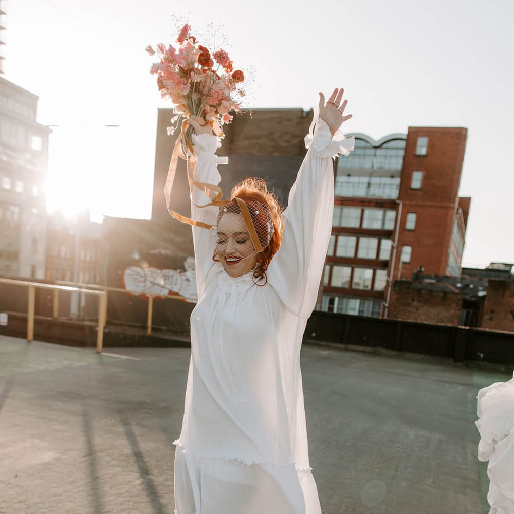Fun bride in a short wedding dress with leopard print shoes and a pearl birdcage veil 