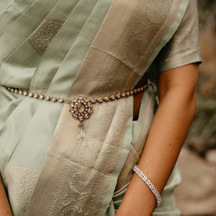 Close up of the mint green saree with golden touches and silver bracelet