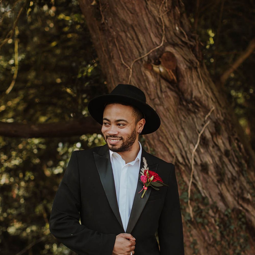Groom in a black suit jacket with satin lapel and open collar shirt at Prestwold Hall wedding 