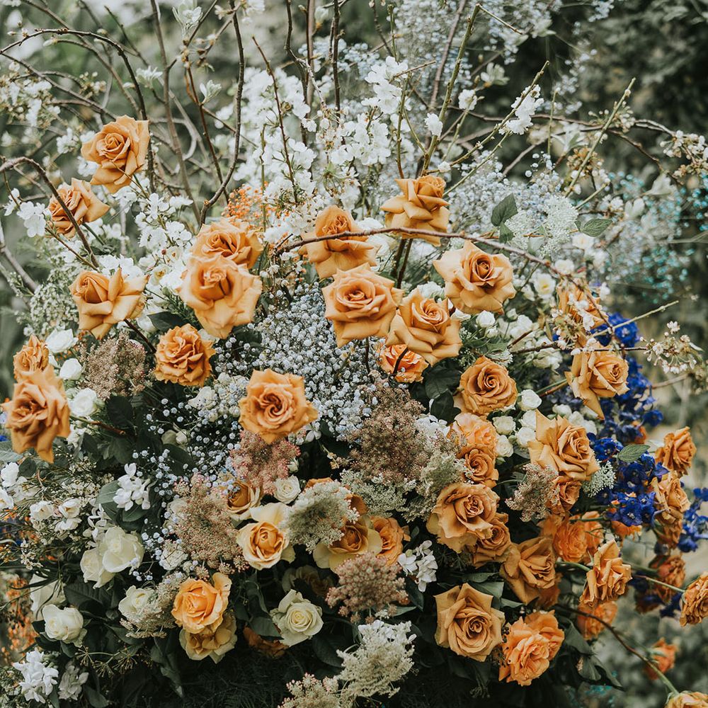 Orange roses with white and blue flowers wedding flower arrangement 