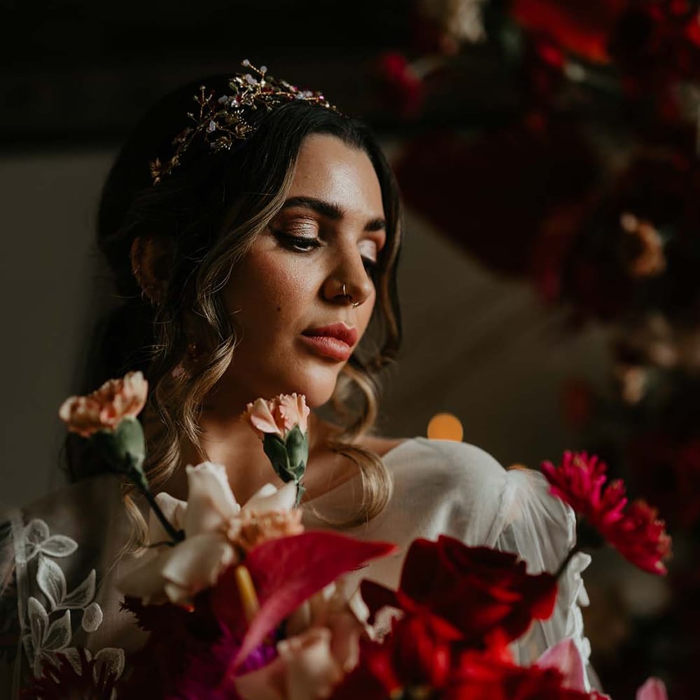 Bride wearing gold bridal flower crown holding hot pink, bright pink and viva magenta bridal bouquet with dahlias, orchids, roses, anthuriums and dried flowers 