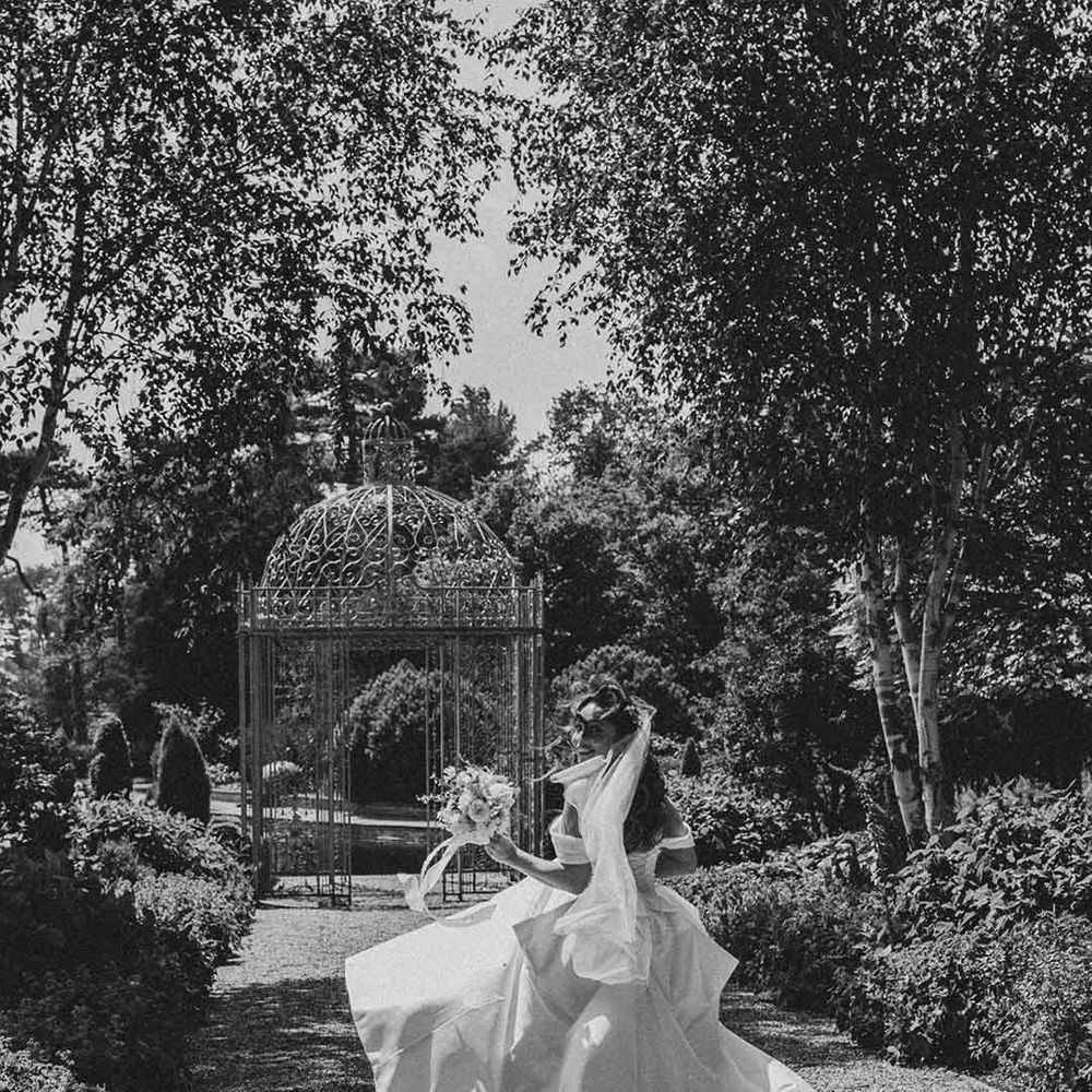 bride in a strapless princess wedding dress running through the gardens at Capesthorne Hall