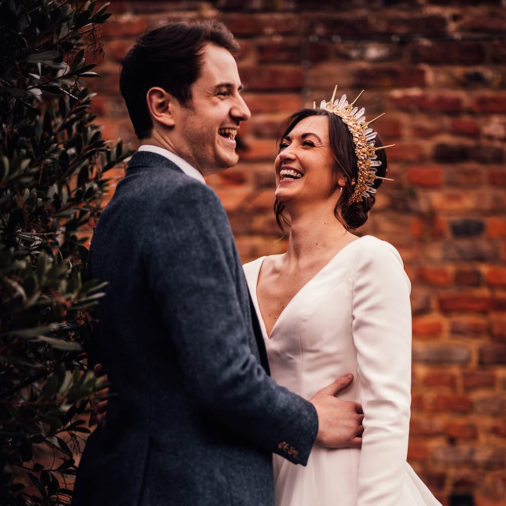 Groom in navy tweed suit with the bride wearing a crystal bride crown with long sleeve wedding dress 