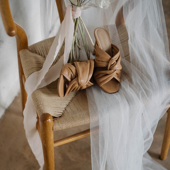 brown mules and wedding veil on a chair 