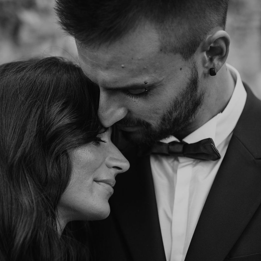 Groom kissing his brides forehead