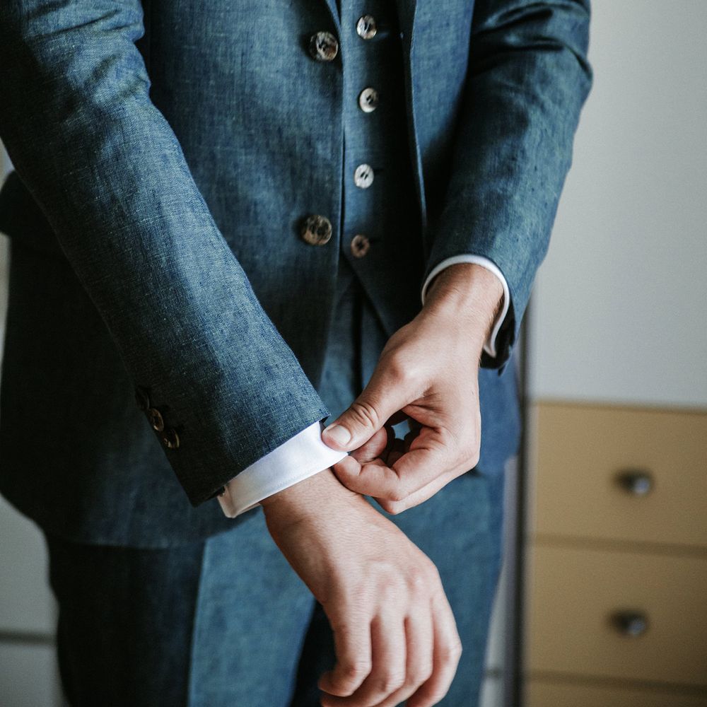 Groom in a navy blue three piece wedding suit on the wedding morning 