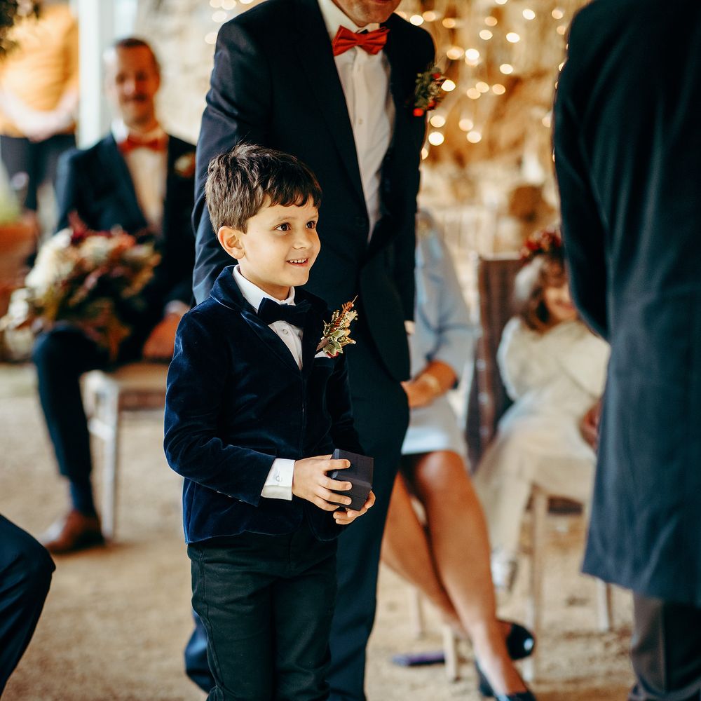 Pageboy in deep blue suit and trainers