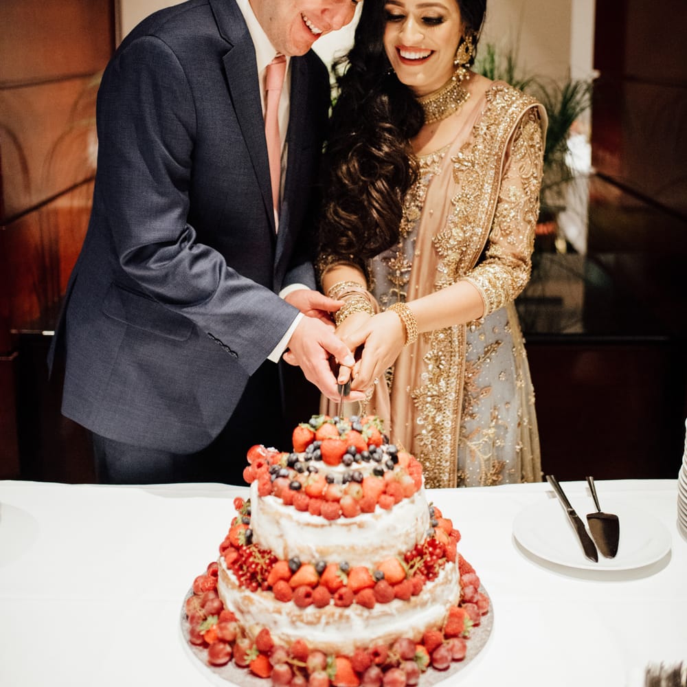 Bride & groom cut wedding cake during wedding reception
