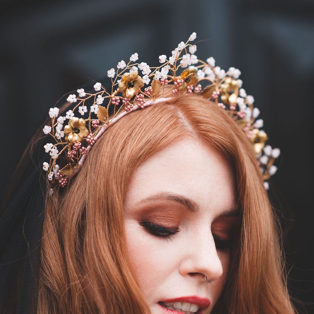 Bride with long auburn hair in a wire headdress with brown eyeshadow and coral lipstick
