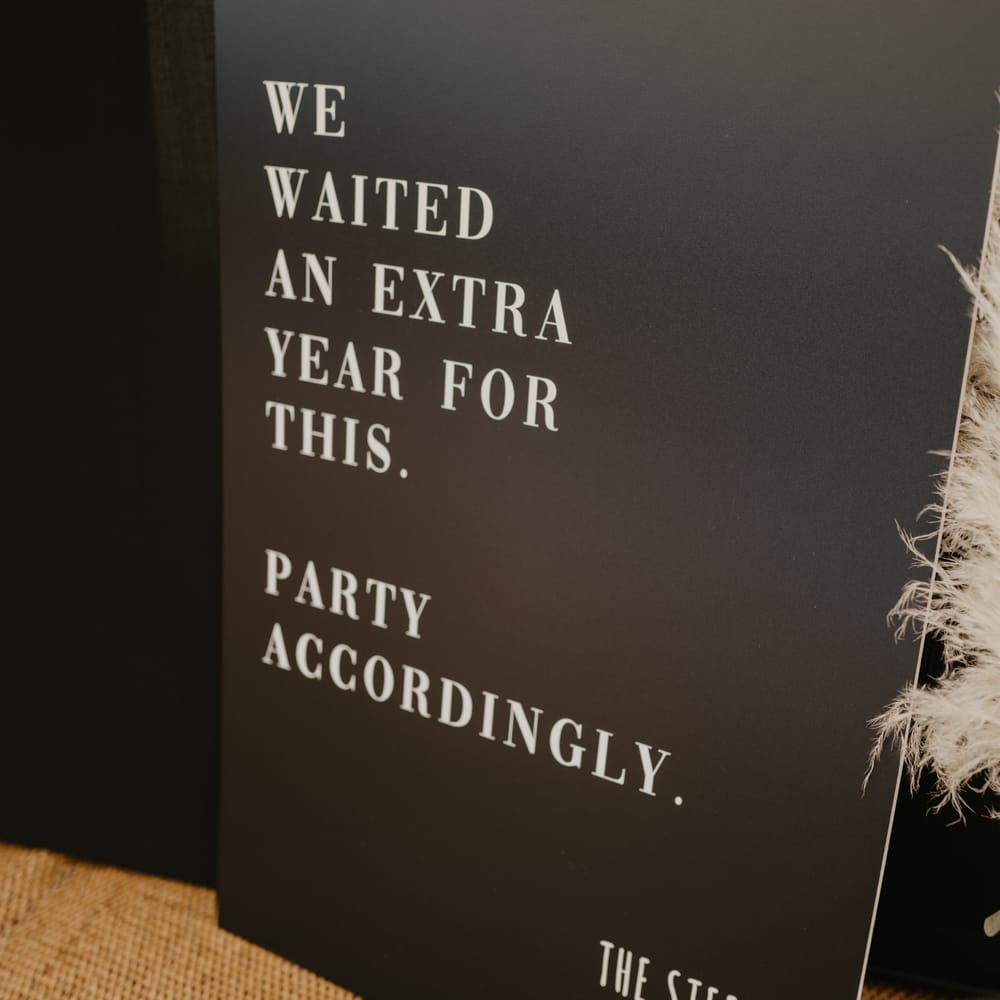 Personalised black board asking guests to 'party accordingly' due to extra wait for wedding day | Mark Bamforth Photography