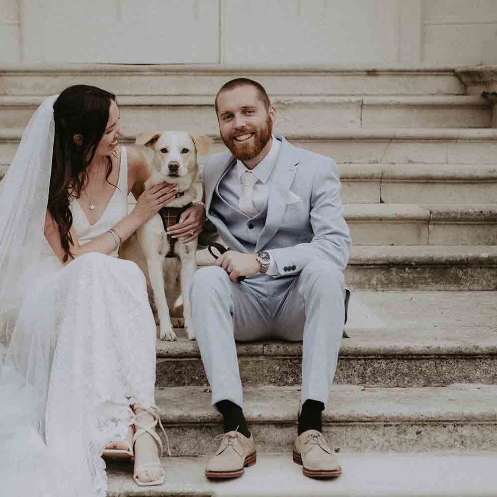 Bride and groom with their pet dog at wedding