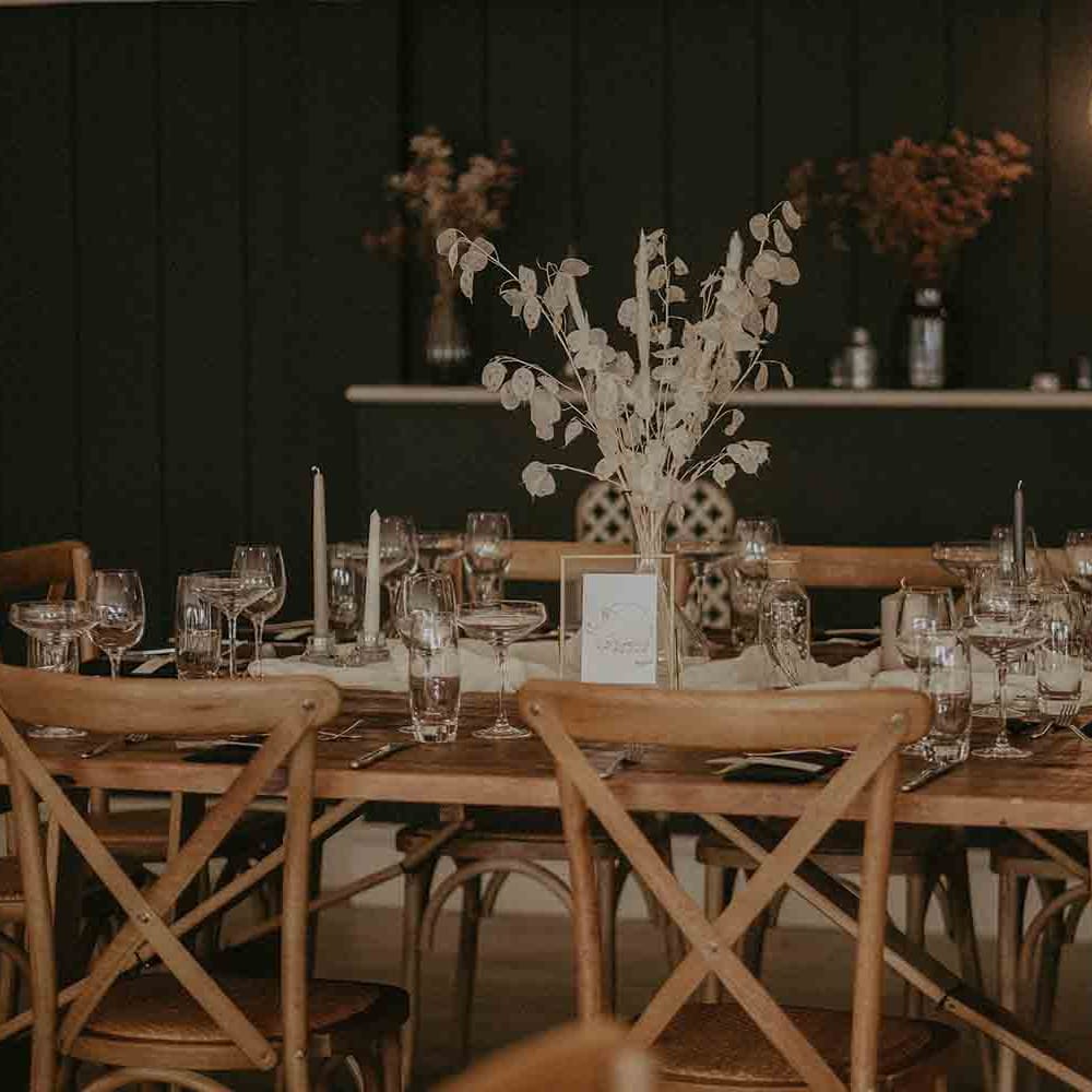 Wooden tables at wedding with dried flower arrangement centrepieces