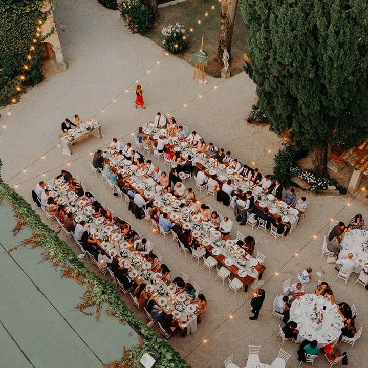 Birdseye view of outdoor Italian wedding complete with wooden tables and fairy lights | Royal Studio