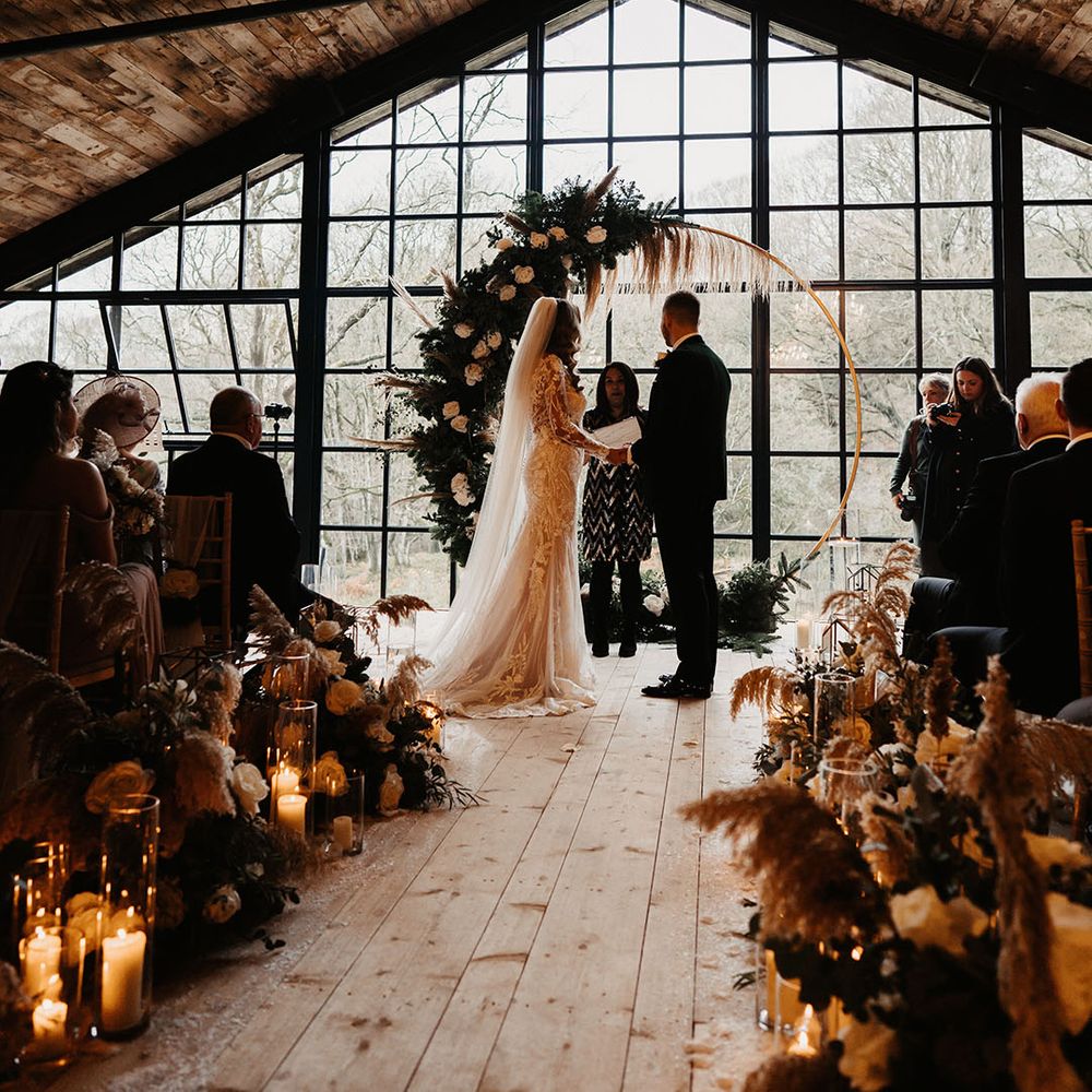 Candle lanterns and dried flower aisle decoration with moongate flower decoration at the altar for Hidden River Barn wedding
