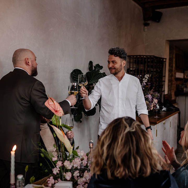 Groom and best man toasting at wedding reception 