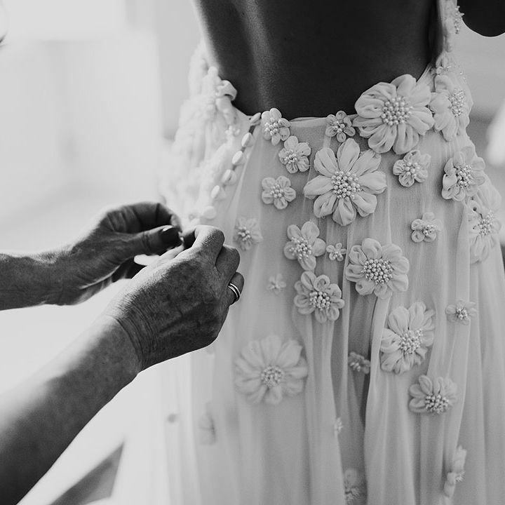 Details on the bride's Emma Beaumont wedding dress with flowers and tiny pearls 