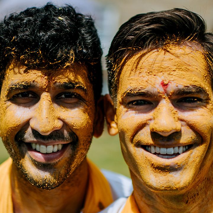 Grooms faces are covered in Haldi paste outdoors after ceremony at The Tithe Barn Bolton Abbey