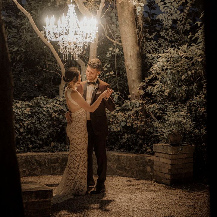 Intimate first dance for the bride and groom under chandelier 