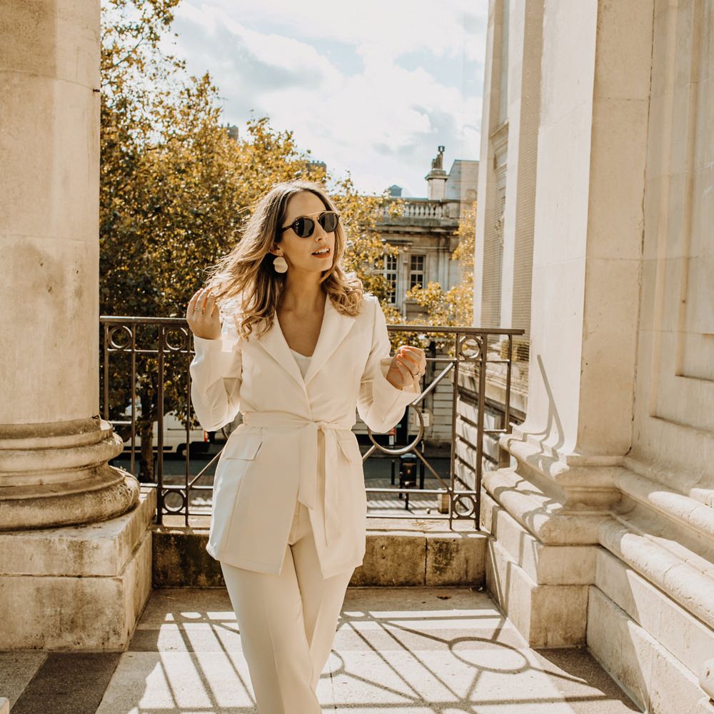 Bride in high street trouser suit and sunglasses at city elopement 