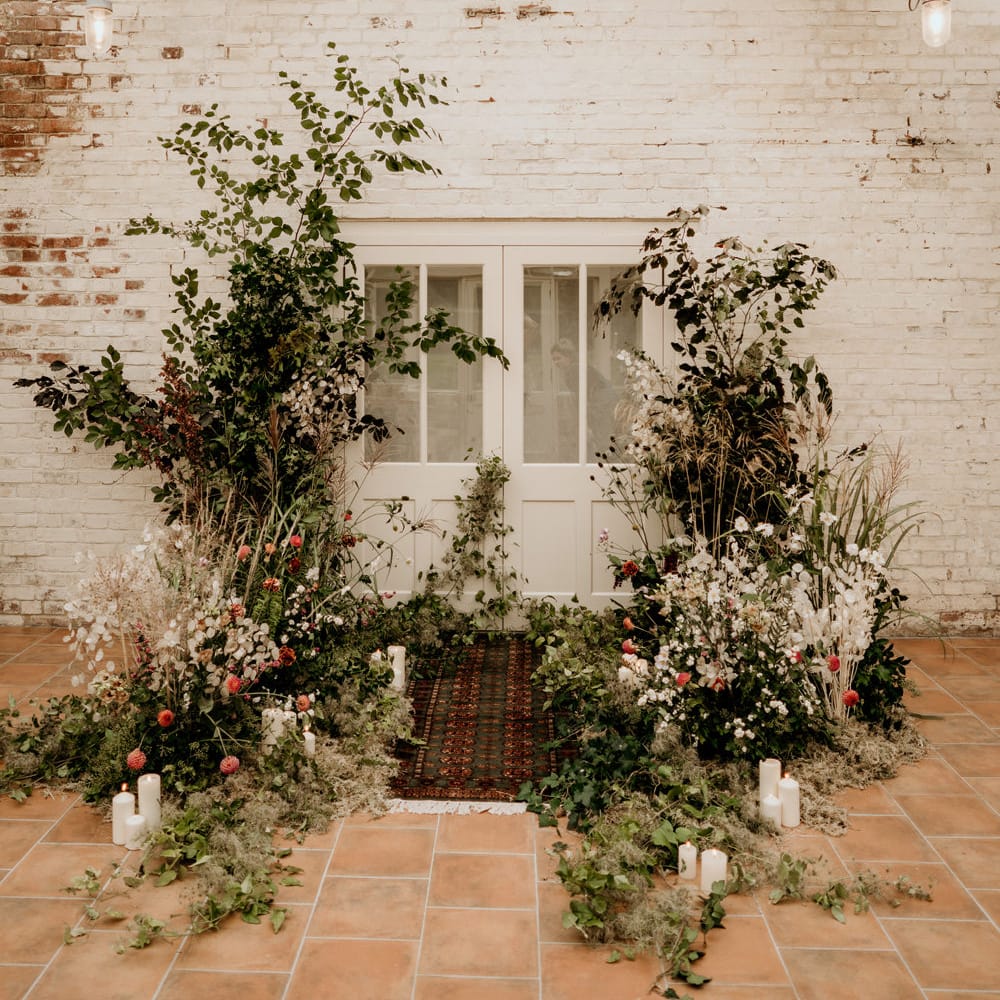 Elopement at Our Beautiful Glasshouse in Sussex with wildflower altar and wool rug detail 