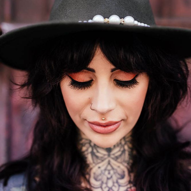 Alternative bride with neck tattoos, fedora hat and winged eyeliner 