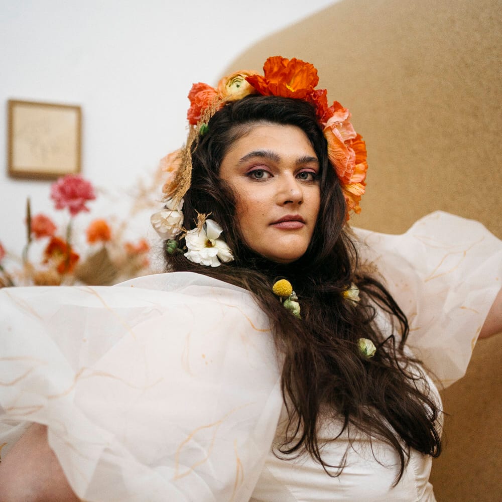 Bride wearing an orange and white fresh flower crown made up of poppies