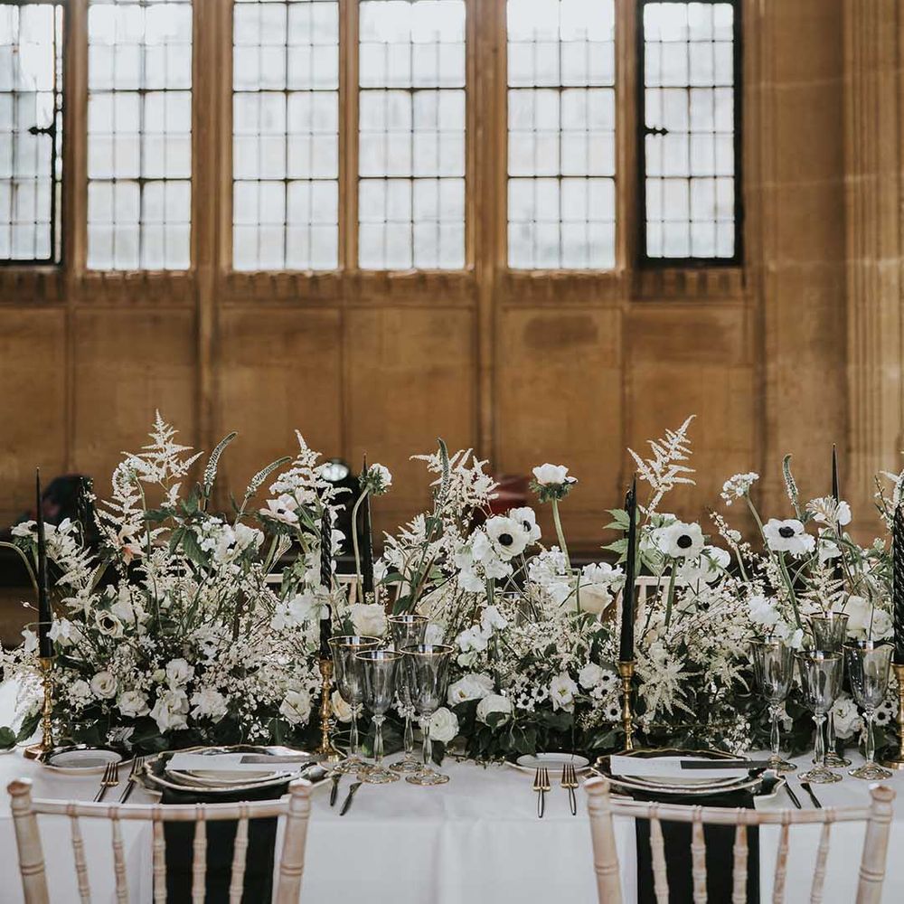 Wedding table decor with black plates and white flower centrepiece