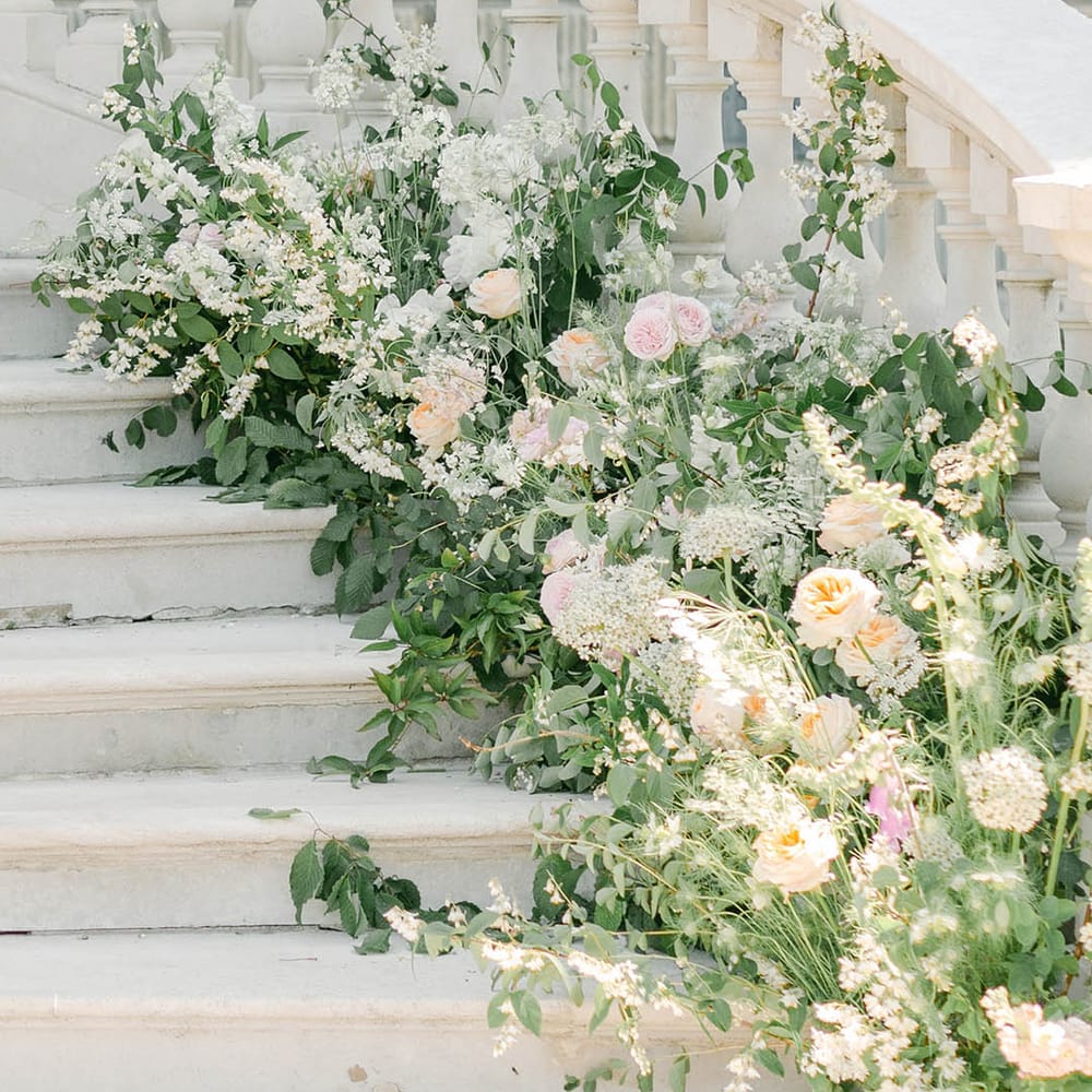 staircase wedding flowers at Botley's Mansion with roses, peonies, Icelandic poppies, sweet peas, scabious, foxglove, and snapdragons