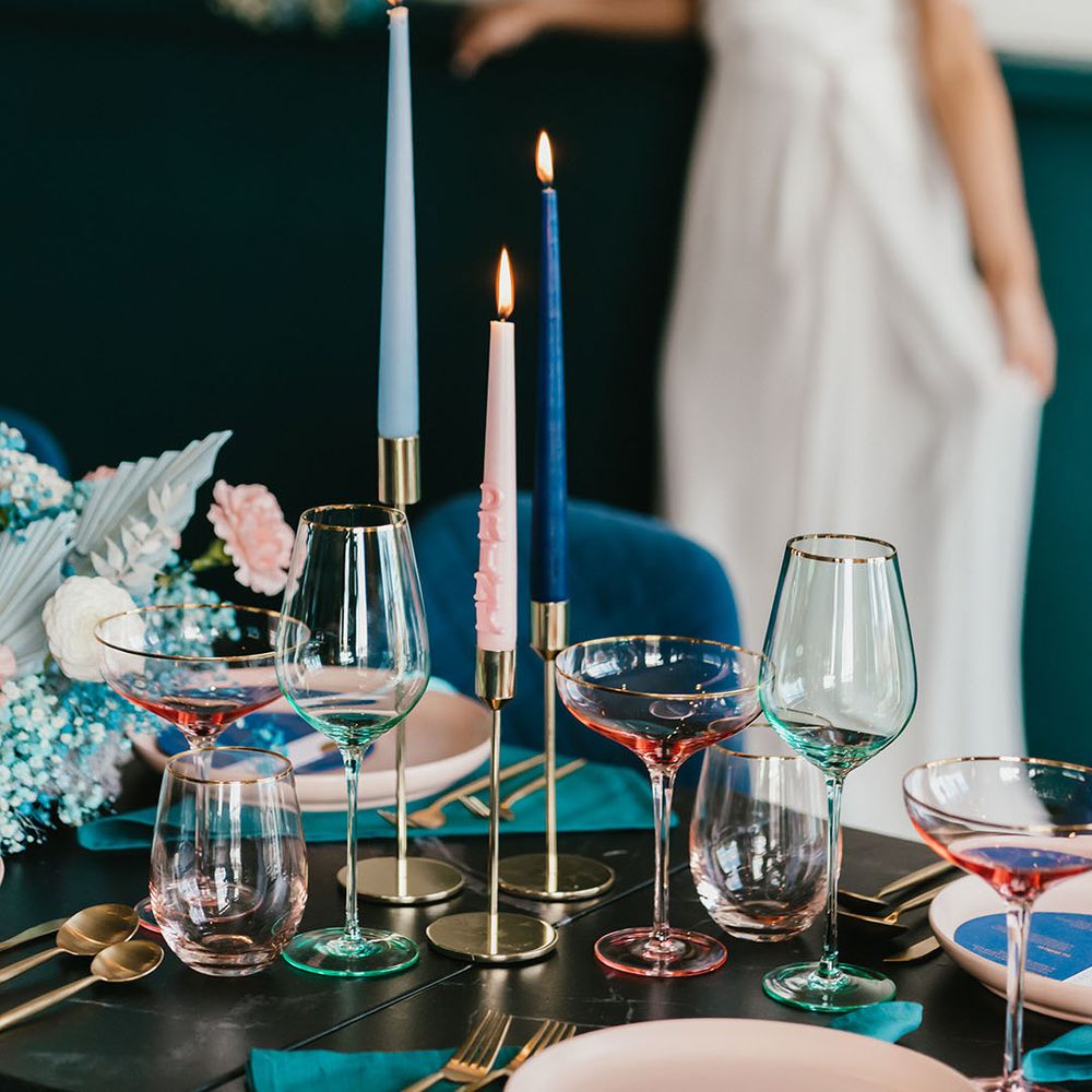 pink, navy blue and teal green wedding table decor with coloured glass and taper candles 
