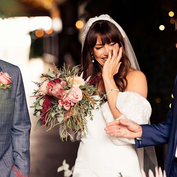 Father of the bride in a blue suit giving his daughter away at the altar 