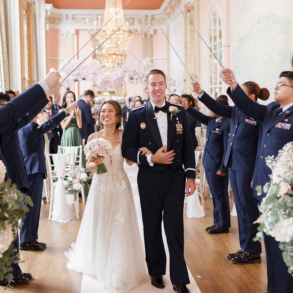 Bride & groom leave under Sabre Arch after wedding ceremony 