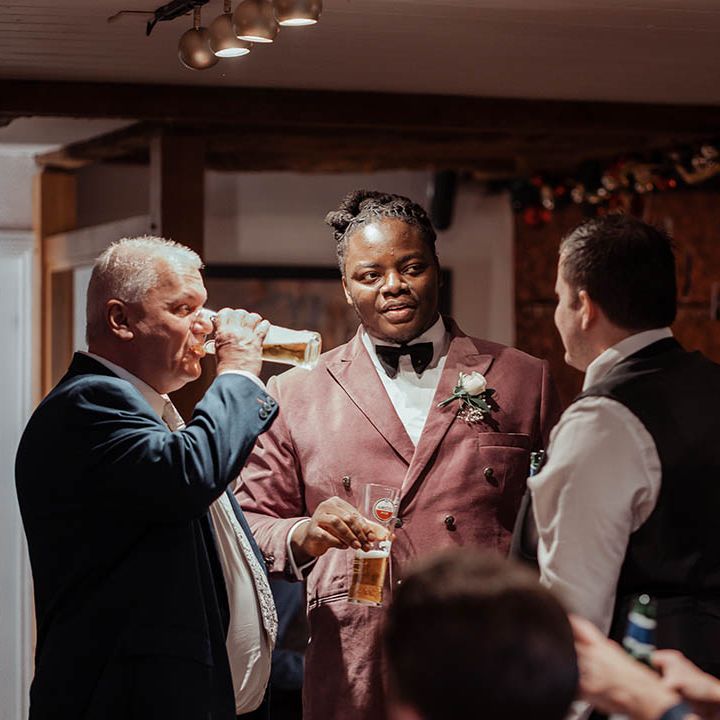 Wedding guests mingle with groom during wedding reception