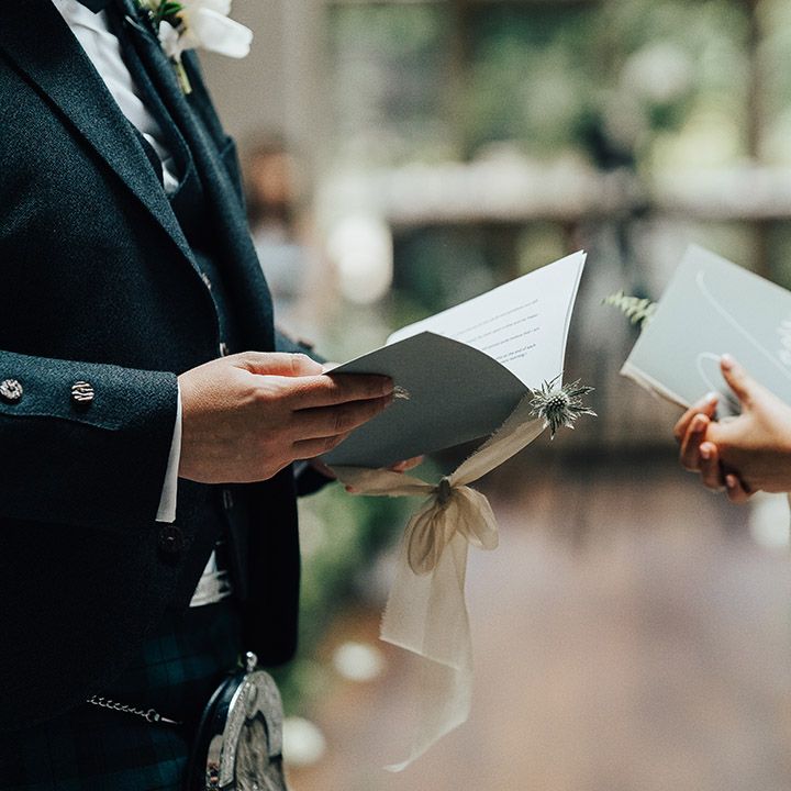 Bride and groom reading their personalised wedding vows at the altar 