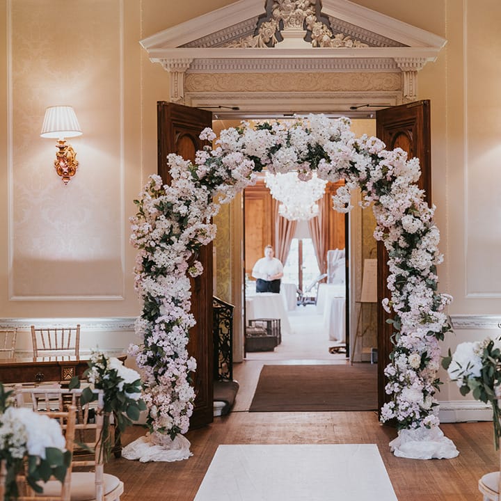 Classic country house wedding venue with pink and white flower wedding arch 