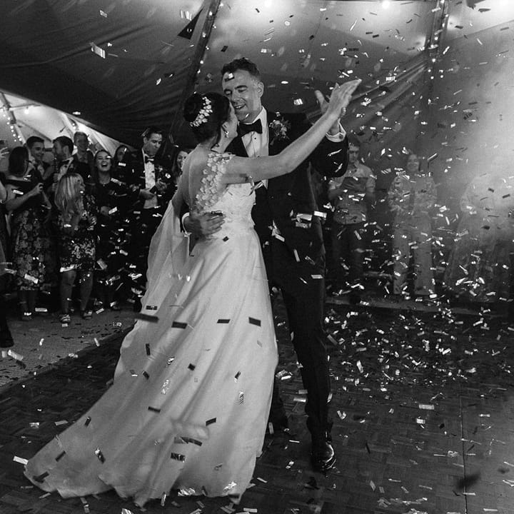 The bride and groom share their first dance together with gold confetti canon exploding 