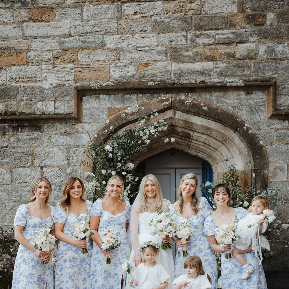 Bridal party with flower girls posing together for group photo 