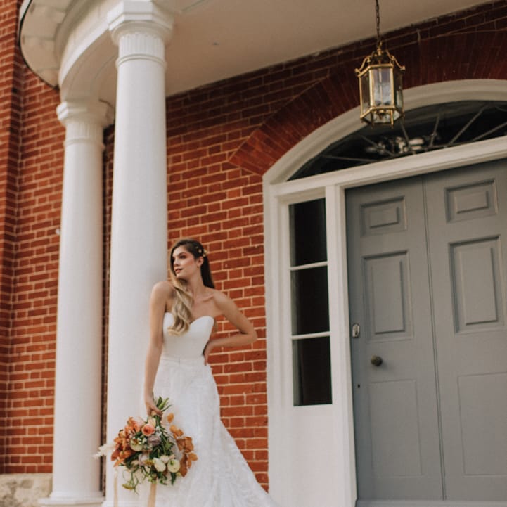 Bride holding autumn flower bouquet at Reymerston Hall