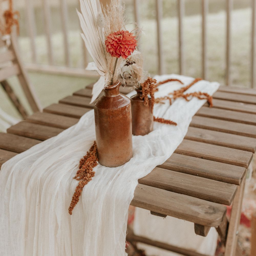 Flowers in brass vases on white table cloth